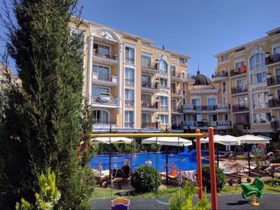 a large apartment building with a pool and a playground at Апартамент с одной спальней in Sunny Beach