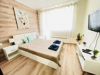 a small bedroom with a bed and a television at Glarus in Varna City