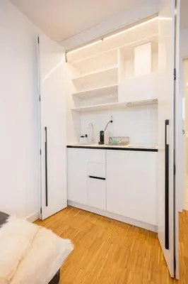 a kitchen with white cabinets and a door open at Apartment Musala N 02 in Varna City