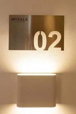 a sign on a wall that readsmuskaemia with a light at Apartment Musala N 02 in Varna City