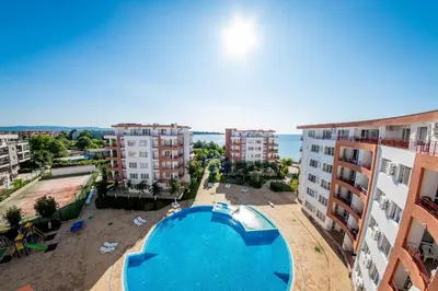 an apartment with a swimming pool and some buildings at Riviera Fort Beach Apartment in Ravda