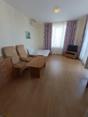 a hospital room with a bed and a table and chairs at Riviera Fort Beach Apartment in Ravda