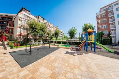 a playground with a slide and a swing set at Riviera Fort Beach Apartment in Ravda