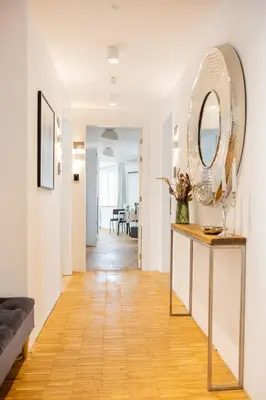 a living room with a table and a mirror at Apartment Musala N 03 in Varna City
