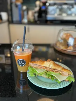 a sandwich on a plate and a drink on a table at Apartment Musala N 03 in Varna City