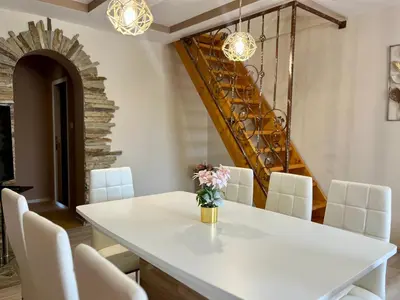a dining room with a white table and white chairs at Villa Teos in Novo Panicharevo