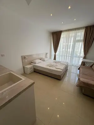 a bedroom with a bed and a large window at Lozenetz Beach Apartments in Lozenets