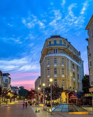 a large building on a city street at dusk at Apartment Musala N 04 in Varna City