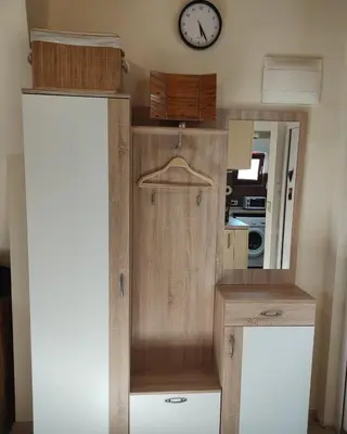 a wooden cabinet with a clock on the wall at Dream Loft in the center of Varna in Varna City
