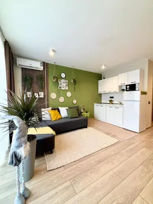 a living room with a black couch and a kitchen at Orchid Fort Noks Design in Sunny Beach