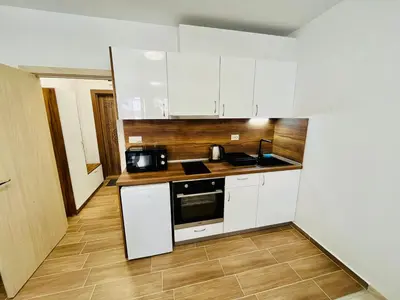 a kitchen with white cabinets and a stove top oven at Апартаменти Тутхон Поморие in Pomorie