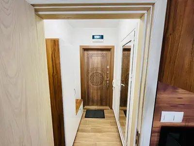 a hallway with a wooden door in a house at Апартаменти Тутхон Поморие in Pomorie