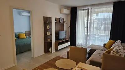 a living room with a couch and a television at Vladan apartments in Sozopol