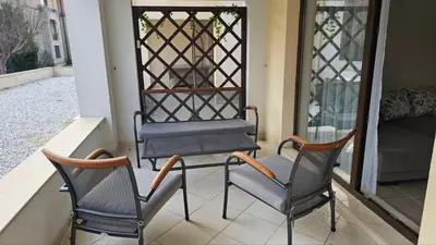 two chairs sitting on a porch next to a bed at Vladan apartments in Sozopol