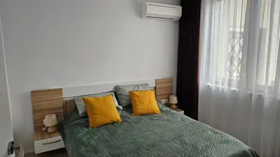a bedroom with a bed with two yellow pillows at Vladan apartments in Sozopol
