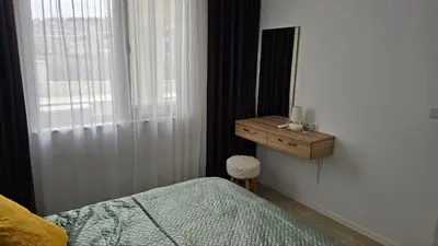 a bedroom with a bed and a dresser and a mirror at Vladan apartments in Sozopol