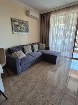 a living room with a blue couch in a room at Private Apartments Olymp in Sveti Vlas