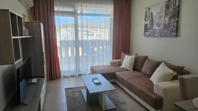 a living room with a couch and a tv at Vladan apartments in Sozopol