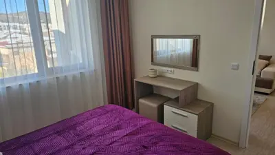a bedroom with a purple bed and a mirror at Vladan apartments in Sozopol