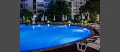 a large blue swimming pool with chairs and umbrellas at Cozy private studios Excelsior Sunny Beach in Sunny Beach