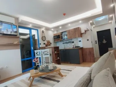 a living room with a couch and a table and a kitchen at Cozy private studios Excelsior Sunny Beach in Sunny Beach