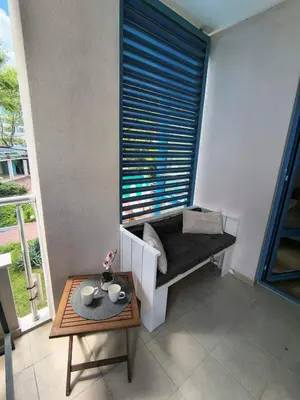 a room with a window with a bench and a table at Cozy private studios Excelsior Sunny Beach in Sunny Beach