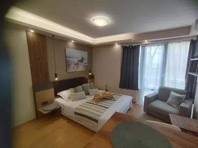a bedroom with a bed and a couch and a chair at Cozy private studios Excelsior Sunny Beach in Sunny Beach