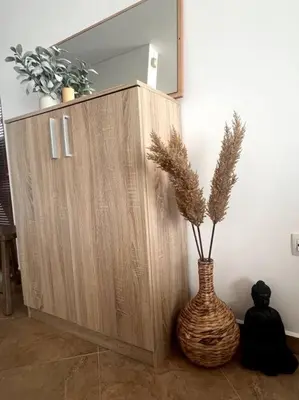 a wooden cabinet with a vase with a plant in it at Panorama Bay-Serenity Haven in Burgas City