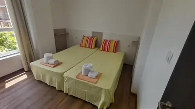 a small bedroom with a bed with two towels on it at Синя пеперуда Blue butterfly in Primorsko