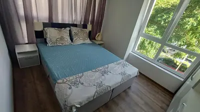 a small bedroom with a bed and a window at Синя пеперуда Blue butterfly in Primorsko