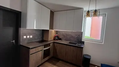 a small kitchen with white cabinets and a window at Синя пеперуда Blue butterfly in Primorsko