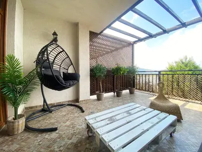 a patio with a swing and a bench on a balcony at Santa Marina Sun&Sea Haven in Sozopol