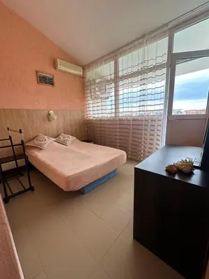 a bedroom with a bed and a desk and a window at Elit 2 Apartment in Sunny Beach