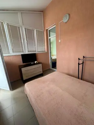 a bedroom with a bed and a tv and a window at Elit 2 Apartment in Sunny Beach