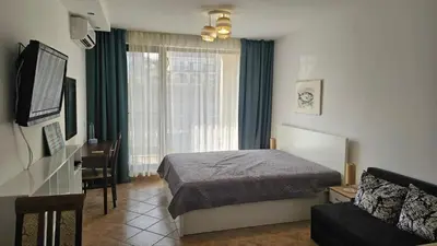 a hotel room with a bed and a window at Vladan apartments in Sozopol