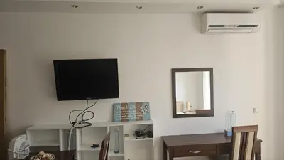a living room with a television on the wall at Vladan apartments in Sozopol