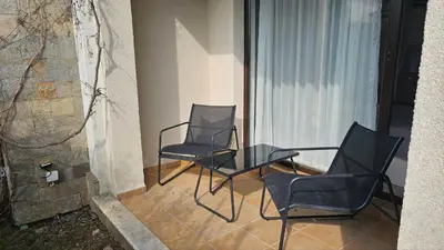 two chairs and a glass table on a balcony at Vladan apartments in Sozopol