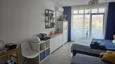 a small bedroom with a bed and a window at Vladan apartments in Sozopol