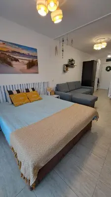 a bedroom with a large bed and a couch at Vladan apartments in Sozopol