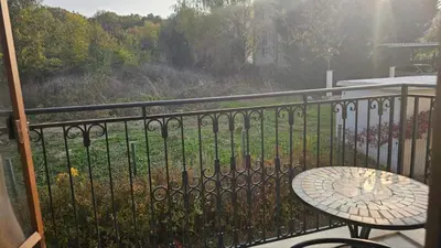 a balcony with a table and a view of a yard at Vladan apartments in Sozopol