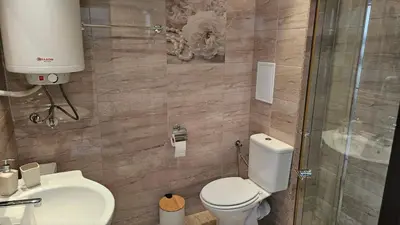 a bathroom with a toilet and a sink and a shower at Vladan apartments in Sozopol
