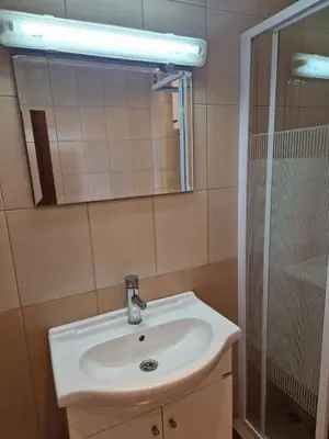 a bathroom with a sink and a mirror and a shower at SunBreeze Living Apartments in Byala