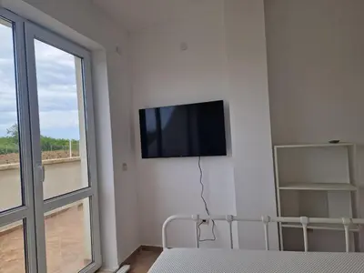 a bedroom with a flat screen tv on the wall at SunBreeze Living Apartments in Byala