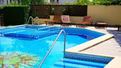 a swimming pool with two chairs and a swimming pool at Бяла Виста Бийч Апартментс A - Byala Vista Beach Apartments A in Byala