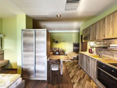 a kitchen with wooden cabinets and a chair in it at Hotel Continental in Kiten