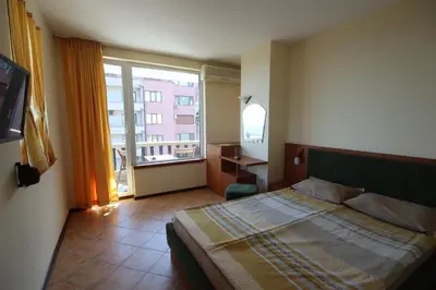 a bedroom with a bed and a large window at Hotel Continental in Kiten