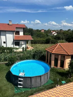 a large swimming pool in the yard of a house at Rose Villa in Trŭstikovo