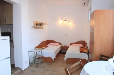 a small room with two beds and a table at Megi Apartments in Sozopol