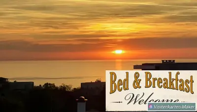 a sunset over the ocean with a sign that says bed and breakfast at Sunshine Byala 2 in Byala