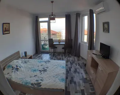 a bedroom with a bed and a desk with a television at Sunshine Byala 2 in Byala
